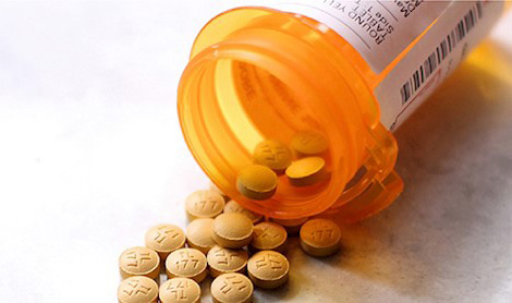 closeup of pills spilling from a prescription bottle